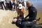 Rescuer teaching male beachgoer of an artificial respiration, pressing on a drowning chest by hands