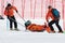 Rescuers evacuated injured skier sportsman from mountain on rescue stretchers