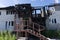 Rescuers firefighters extinguish a fire on the roof. The building after the fire. Burnt window. Ruined house. Catastrophe. Soot on