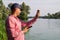 Researcher ecologist with tablet examines tube with green algae outside