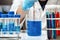 Researcher holding beaker with blue liquid for analysis of fluids in the lab