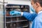 Researcher introducing a petri dish into an incubator