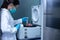 Researcher woman using the centrifuge machine to separate between precipitate from the sample solution with 100 ml centrifuge