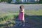 Resentful child is standing and don`t want to go anywhere defend own position Little girl in pink sundress at summer