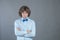 Resentful man with arms folded over gray background in studio shot and offended looked at camera. Angry grumpy guy looking very