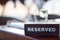 Reserved wooden Card Plate on the Table with Blurry background. Reservation Seat at restaurant. - leisure, people and service conc