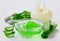 Resh aloe vera leaf and aloe gel with burning candles on white surface