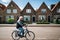 Resident of the village of Volendam by bike in front of the typical traditional houses, Netherlands.