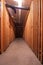 Residential apartment building basement or cellar corridor with wooden doors of tenant`s storage places. Dark dimly lit, wide