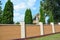 Residential brick fence. Brick Fencing with thuja trees