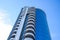 Residential building with balconies, multi-storey building. Building against the blue sky with clouds