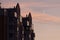 The residential building reflects in the tile and glass a beautiful sunset sky against the backdrop of a growing moon.