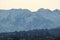 Residential buildings on a hillside against the backdrop of the snow-capped mountains of Trans-Ili Alatau in a winter morning