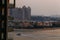 Residential buildings and hotels of Palm Jumeirah during sunset, with a blurry boat sailing past.