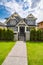 Residential family house with concrete pathway over green lawn on the front yard