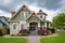 Residential family house with concrete pathway over green lawn on the front yard