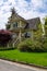 Residential family house with stairwell to main entrance and green lawn in front