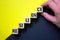 Resilience symbol. Wood cubes with word `resilience` stacking as step stair on paper yellow and black background, copy space. Ma