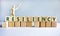 Resiliency symbol. Word `Resiliency` written on wooden blocks. Wooden model of human. Copy space. Beautiful white background.