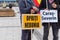 Resita, Romania-March 30, 2021: two protesters at the protests against the restrictive measures with two banners in hand with the