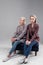 Resolute serious women sitting on little sofa while wearing strict jackets