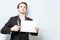 Resolute young business man in black v tshirt and blazer holding blank A4 signboard and pointing with finger at it. Business