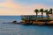 Resort area near hotel in Turkey. Scenic morning landscape view of embankment with empty chaise lounges and palm trees.