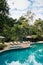 Resort style beach daybeds and umbrellas by swiming pool in tropical garden, Kanchanaburi, Thailand