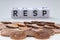 RESP letters on white blocks with coins on a clear background