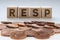 RESP letters on wooden blocks with coins on a clear background