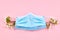 Respiratory surgical face mask on a pink background decorated spring flowers. pandemic beauty concept