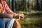 Rest in forest. Man holding cup of tea from thermos while hiking. Relax with wild nature harmony.