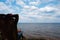 Rest in the forest by the river. A woman relaxes on a sun lounger on a large large river. Backlit leg view