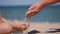 Rest on the sea with children. Sand is poured from the palms of the hands into the palms of the child.