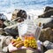 Rest by the sea with grapes, apples, pears, baguettes, wine and a basket on the coverlet