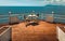 Rest by the sea. Table and chairs on a wooden terrace with a beautiful view of the sea. Recreation Resort Concept