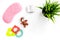 Rest for young mother concept. Sleep mask, plant, alarm clock, toys on white background top view copyspace