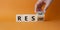 Restart and Resume symbol. Hand turns cubes and changes the word Resume to Restart. Beautiful orange background. Businessman hand