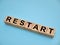 Restart, text written on wooden block, business term