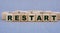 RESTART - word on wooden cubes on a beautiful gray background