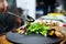 Restaurant chef cooking salad with mussels and greens