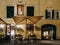 Restaurant entrance with patio tables and religious mural in Italy