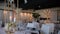 A restaurant filled with tables and chairs and candles on them. Wedding event