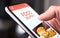 Restaurant food delivery service in phone. Take away menu in digital mobile app. Man ordering takeout pizza or burger online.