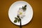 Restaurant food service. Colorful image of flower and fork on the white plate, colorful background, blurry shot.