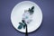 Restaurant food service. Colorful image of flower and fork on the white plate, colorful background, blurry shot.