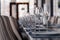 Restaurant interior, serving, wine and water glasses, plates, forks and knives on textile napkins stand in a row on vintage gray