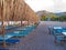 Restaurant and lounge chair on the stoney shores of Nikolaiika Beach on the Corinthian Gulf in Greece