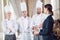 Restaurant manager and his staff in kitchen. interacting to head chef in commercial kitchen