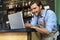 Restaurant manager working on laptop, counting profit